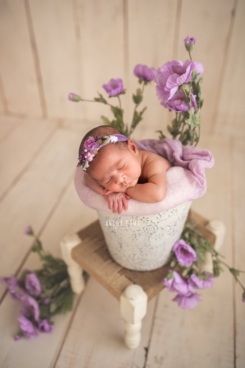 Newborn Photoshoot in Delhi: White Basket with Lavender Flowers, Beige Backdrop. Photographer: Anega Bawa Photography, Gurgaon Noida.