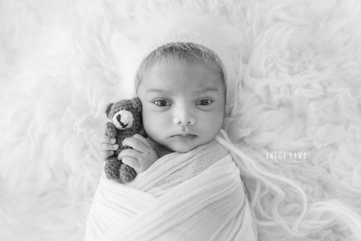Newborn Photoshoot in Delhi: White Wrap with Soft Toy on White Backdrop. Photographer: Anega Bawa, Gurgaon Noida.