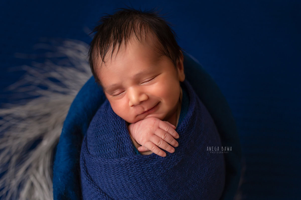 Newborn Photoshoot in Gurgaon: Blue Wrap, Blue Backdrop, Sleeping Pose. Photographer: Anega Bawa, Delhi Noida.