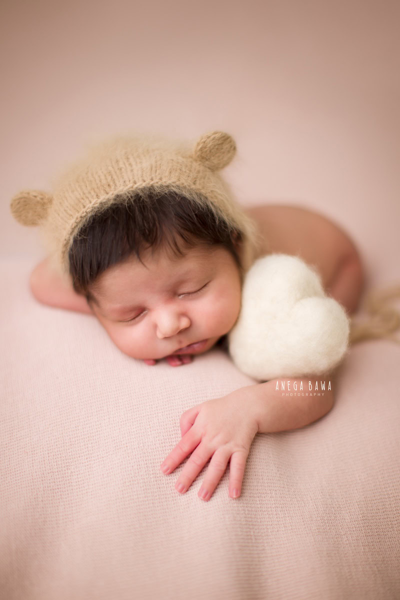 Newborn Photoshoot in Gurgaon: Brown Cap, Beige Sheet. Photographer: Anega Bawa, Delhi Noida.