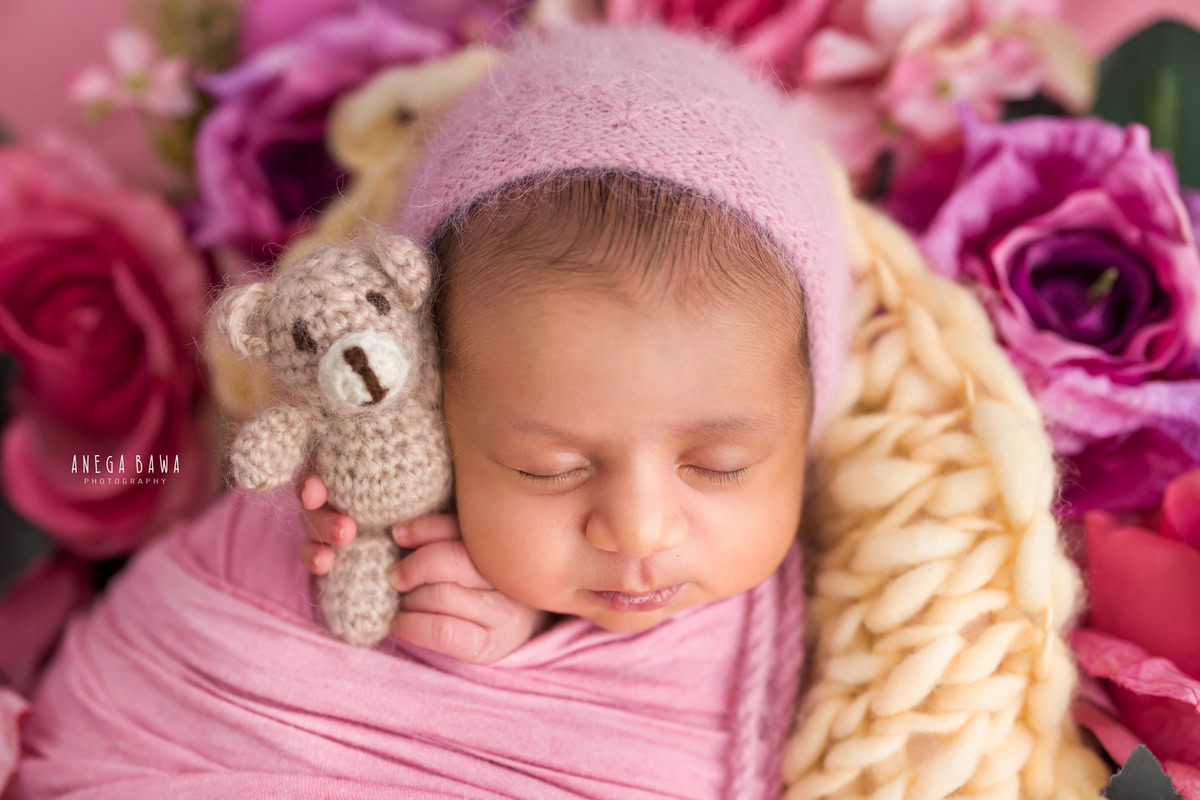 Newborn Photoshoot in Gurgaon: Pink Wrap with a soft toy against a pink backdrop. Photographer: Anega Bawa Photography, Delhi Noida.