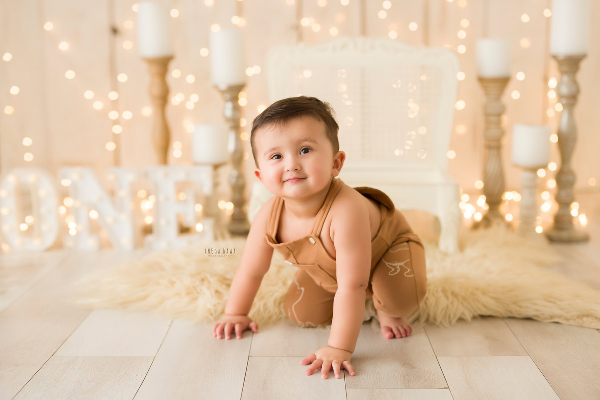 Embark on a magical journey as your one-year-old explores the world around him, crawling amidst the soft glow of fairy lights and the warmth of candlelight on a cozy beige rug. Anega Bawa Photography brings this enchanting moment to life in a captivating sitter photoshoot in Delhi and Gurgaon.