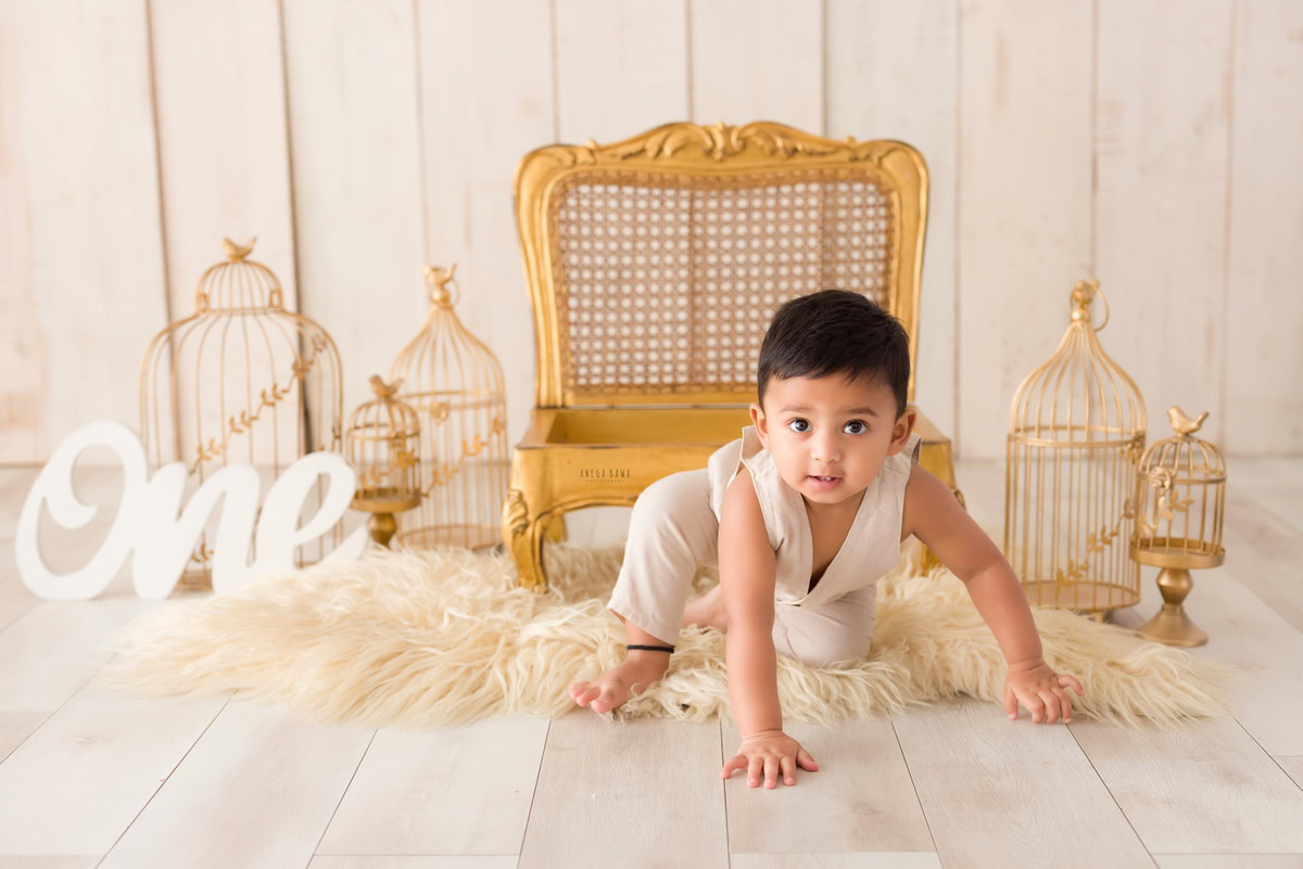 Witness the adventurous spirit of your little one as he explores a kingdom of golden castles, crawling with curiosity on a cozy beige rug. Against a serene beige backdrop, this enchanting moment is captured forever by Anega Bawa Photography in a delightful sitter photoshoot in Delhi and Gurgaon.