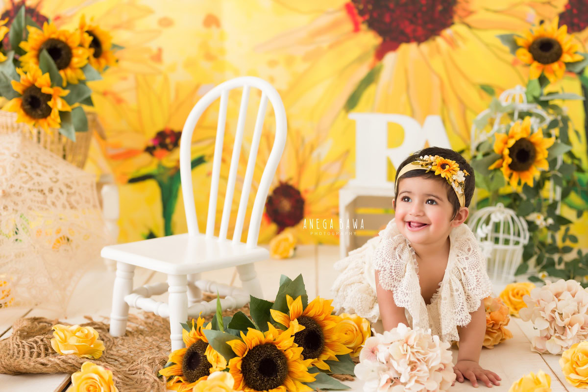 Immerse yourself in the radiant beauty of your little princess with a captivating sitter photography session in Delhi and Gurgaon by Anega Bawa Photography. Picture your one-year-old angel seated amidst a charming sunflower backdrop, adorned with a delightful sunflower headband, and surrounded by whimsical castles on a cozy brown rug. Let Anega Bawa Photography capture these priceless moments, preserving the innocence and joy of your little one forever. Trust us to create stunning memories that you'll cherish for a lifetime.