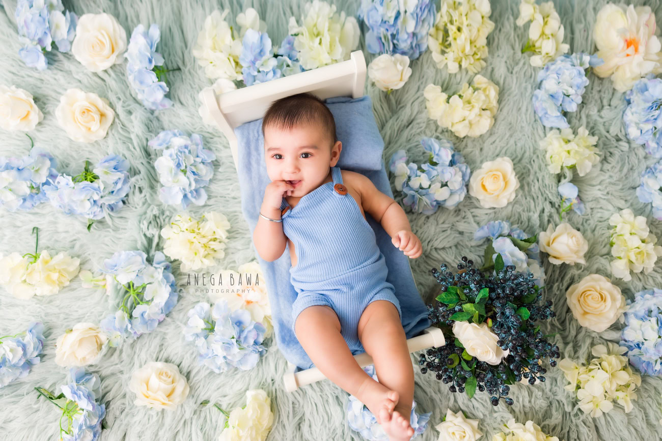 Capture the innocence of your baby boy at 3, 4, 5, or 6 months in a charming baby boy suit surrounded by blue and white flowers. Contact Anega Bawa for your baby boy's photo shoot in Delhi, Gurgaon, or Noida.