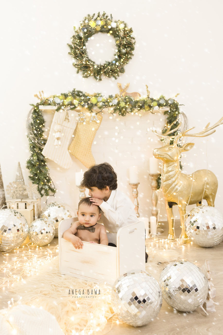 Capture the precious moments of your 3, 4, 5, or 6-month-old baby boy on a beige rug against a white backdrop, surrounded by disco balls and golden lights, with his sibling. Contact Anega Bawa for your baby boy's photo shoot in Delhi, Gurgaon, or Noida.