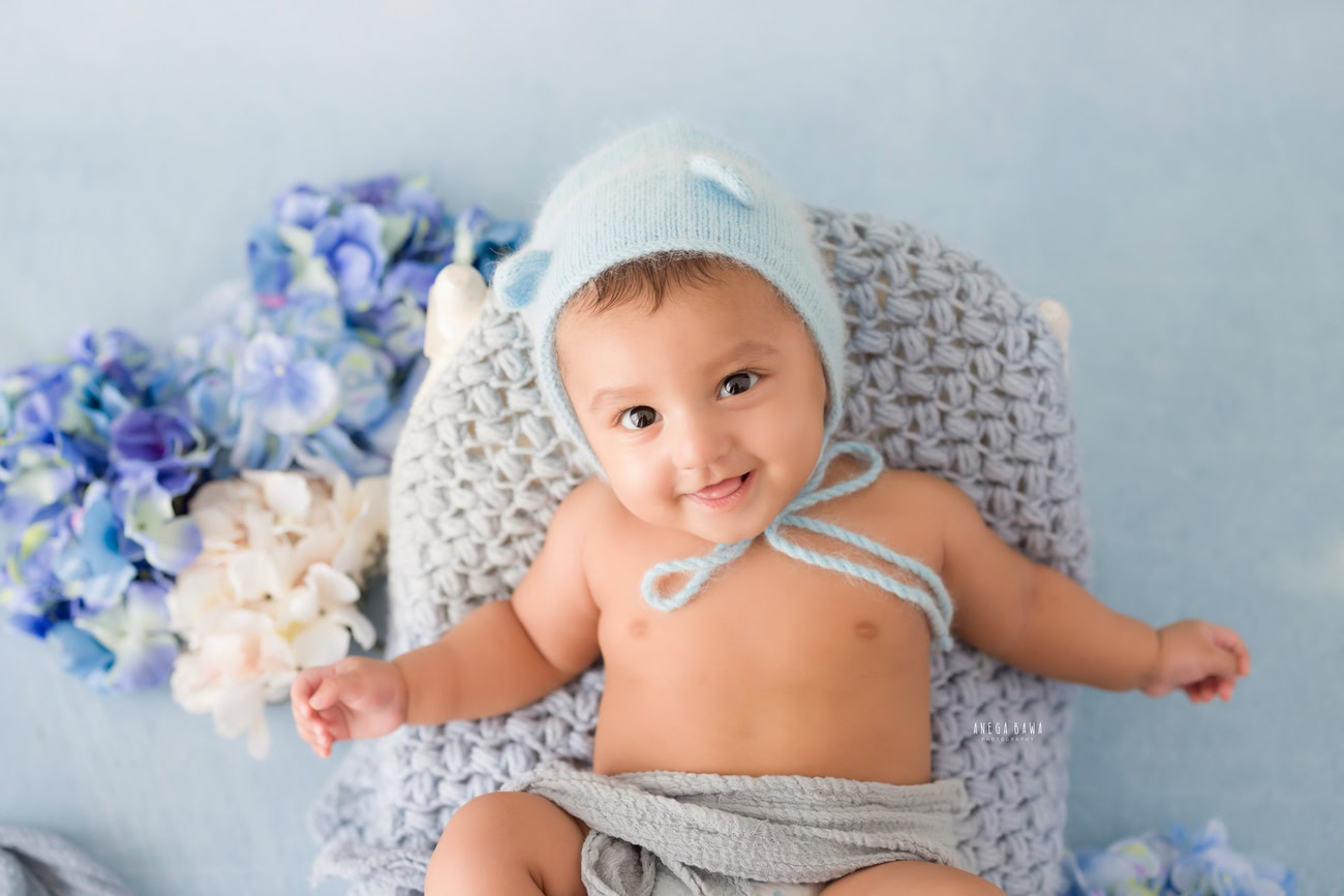 Baby boy photo shoot, 6 or 5 or 3 or 4 months, blue cap, grey wrap, blue backdrop. Location: Delhi, Gurgaon, Noida. Photographer: Anega Bawa.