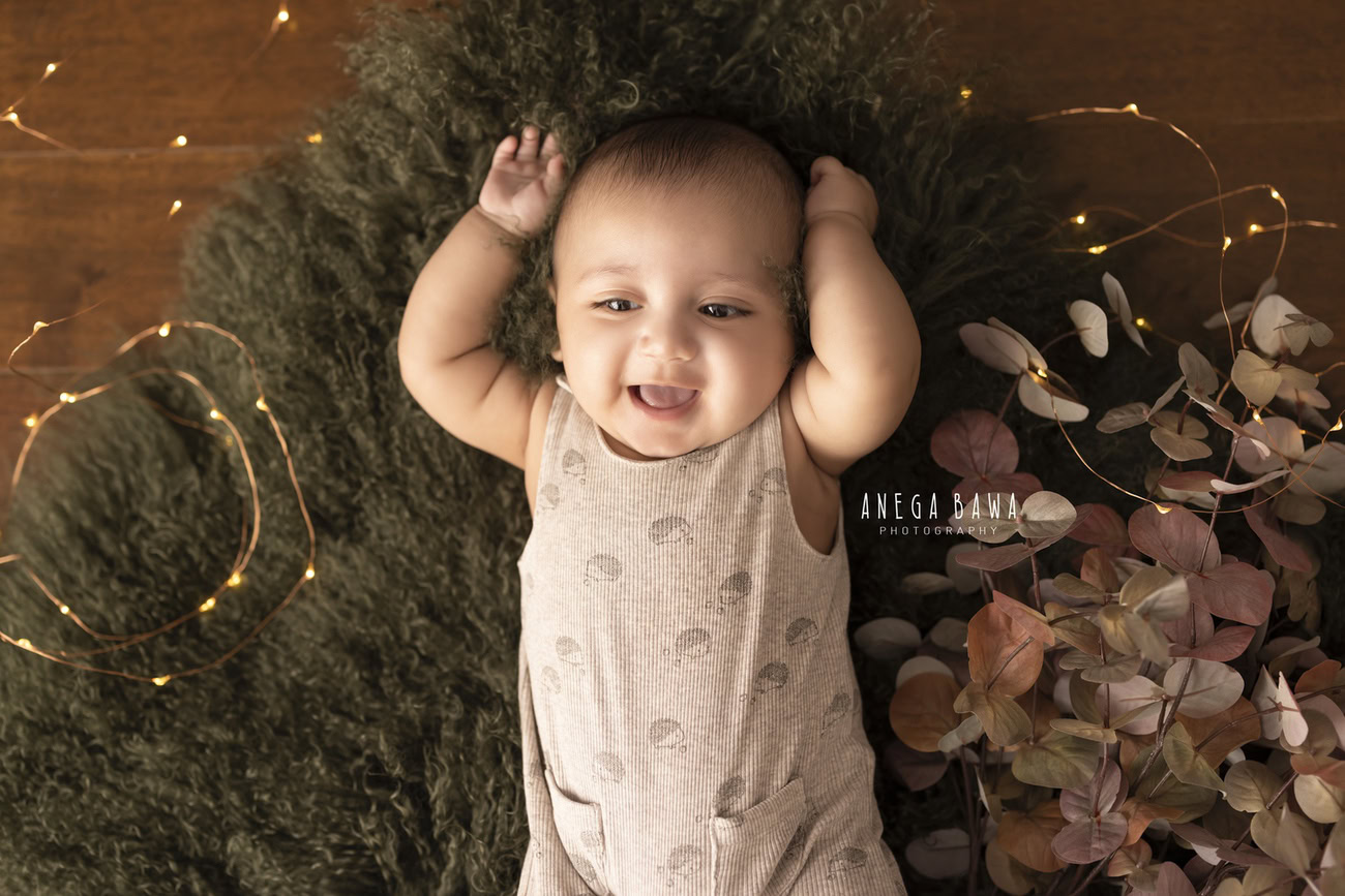 Capture the delightful moments of your little one bathed in the warm glow of golden lights on a plush green rug. Contact Anega Bawa for an enchanting baby boy photoshoot in Delhi, Gurgaon, or Noida.