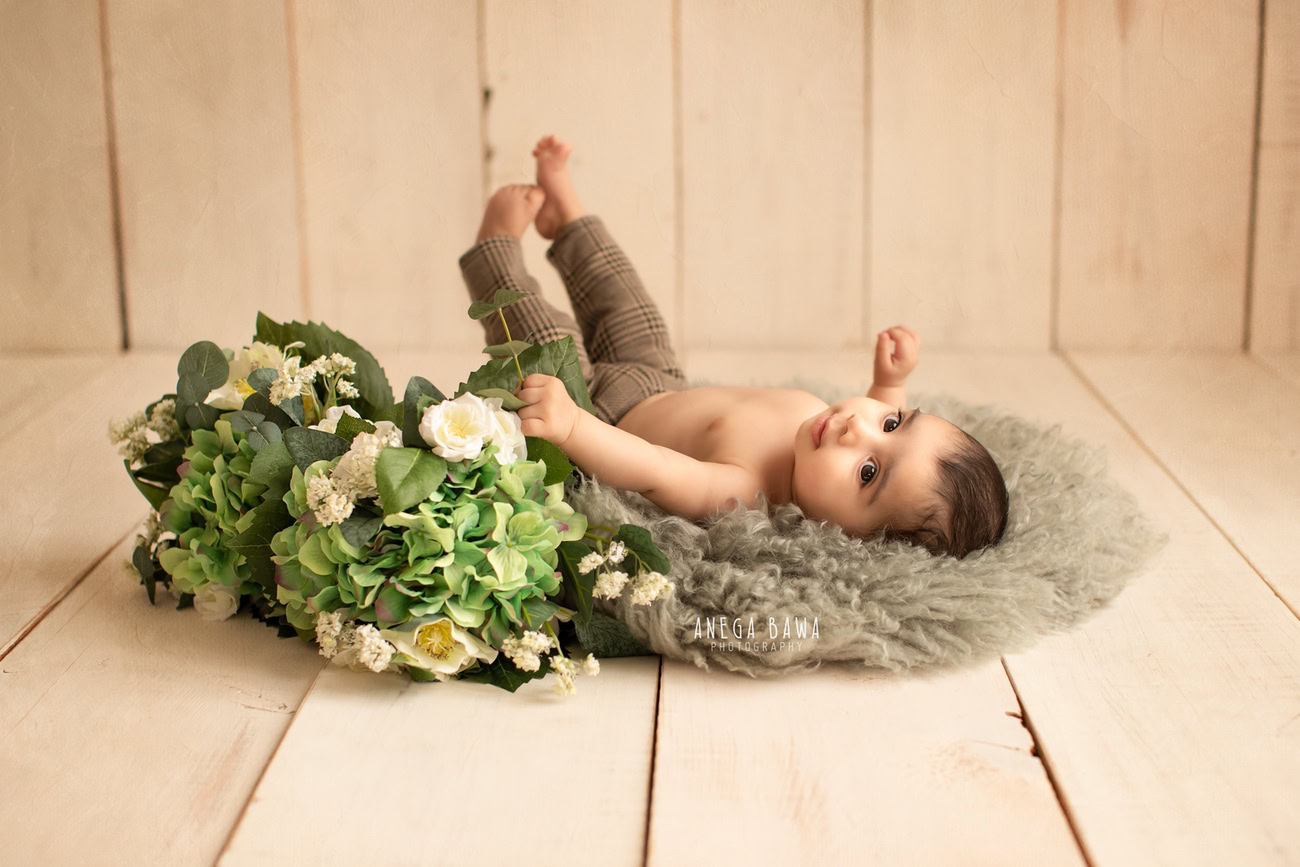 Captivating baby boy photo shoot showcasing 6, 5, 3, 4-month-old charm against a stylish grey rug and elegant beige backdrop. Skillfully crafted by Anega Bawa, the premier baby photographer in Delhi, Gurgaon, and Noida.