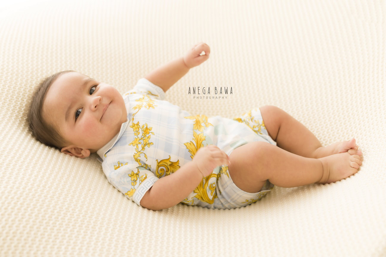 Baby boy photo shoot, 6, 5, 3, or 4 months, white backdrop, lying down pose. Location: Delhi, Gurgaon, Noida. Photographer: Anega Bawa.