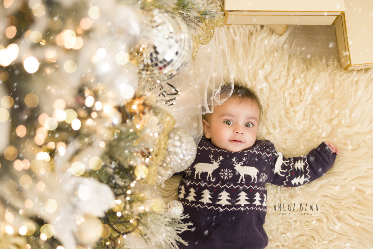 Capture the holiday spirit with your little one in a delightful Christmas-themed photoshoot! Picture him in a cozy Xmas jumper, nestled on a soft beige rug against a serene beige backdrop. Contact Anega Bawa to immortalize these precious moments in Delhi, Gurgaon, or Noida.