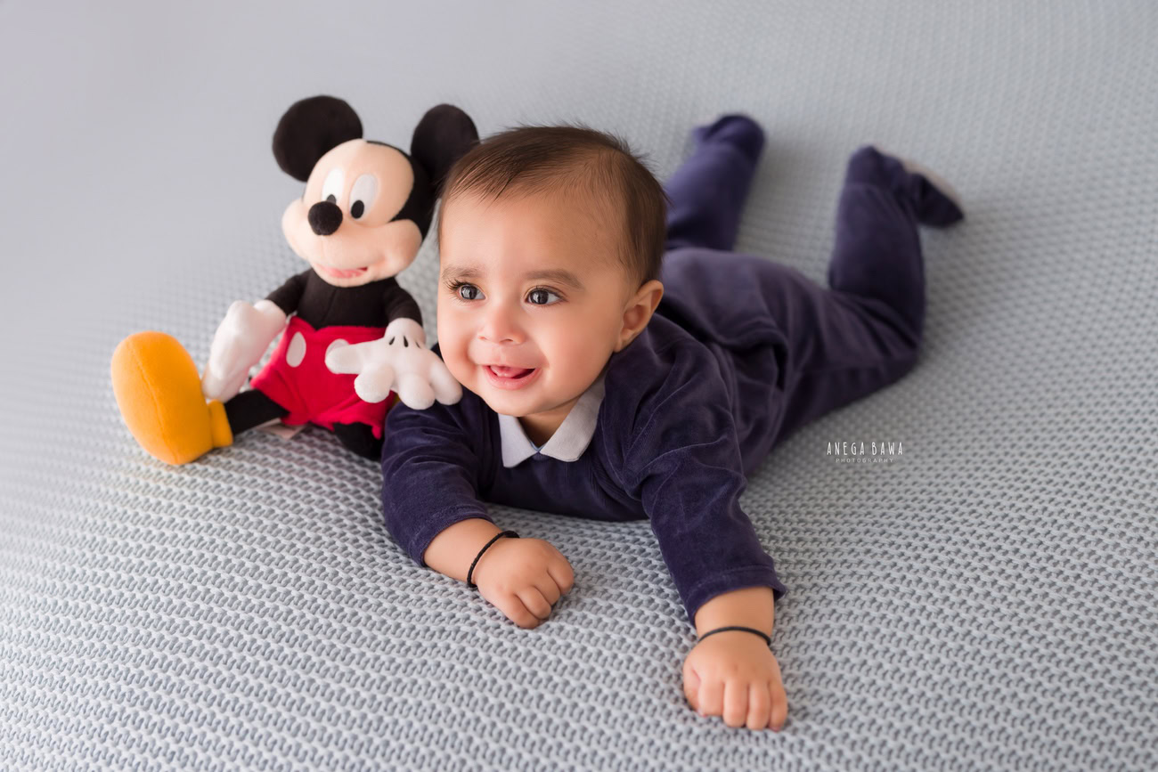 Baby boy photographer, 6 or 4 or 3 or 5 months, grey backdrop, blue baby boy suit, soft toy. Location: Delhi, Gurgaon, Noida. Photographer: Anega Bawa.