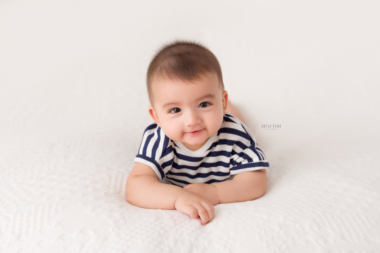 Baby boy photographer, 6 or 4 or 3 or 5 months, white backdrop, blue stripes baby boy suit. Location: Delhi, Gurgaon, Noida. Photographer: Anega Bawa.
