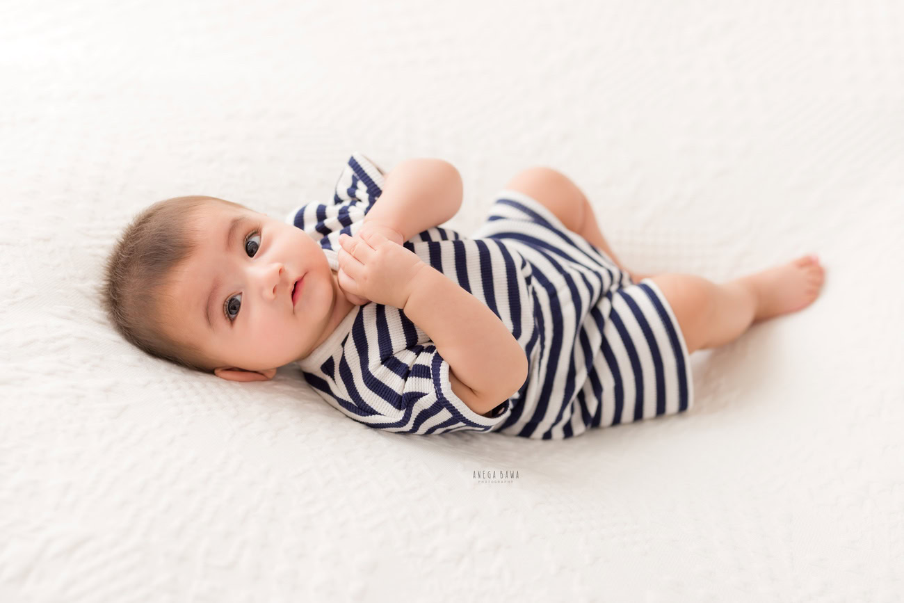 Baby boy photographer, 6 or 4 or 3 or 5 months, white backdrop, blue stripes baby boy suit. Location: Delhi, Gurgaon, Noida. Photographer: Anega Bawa.
