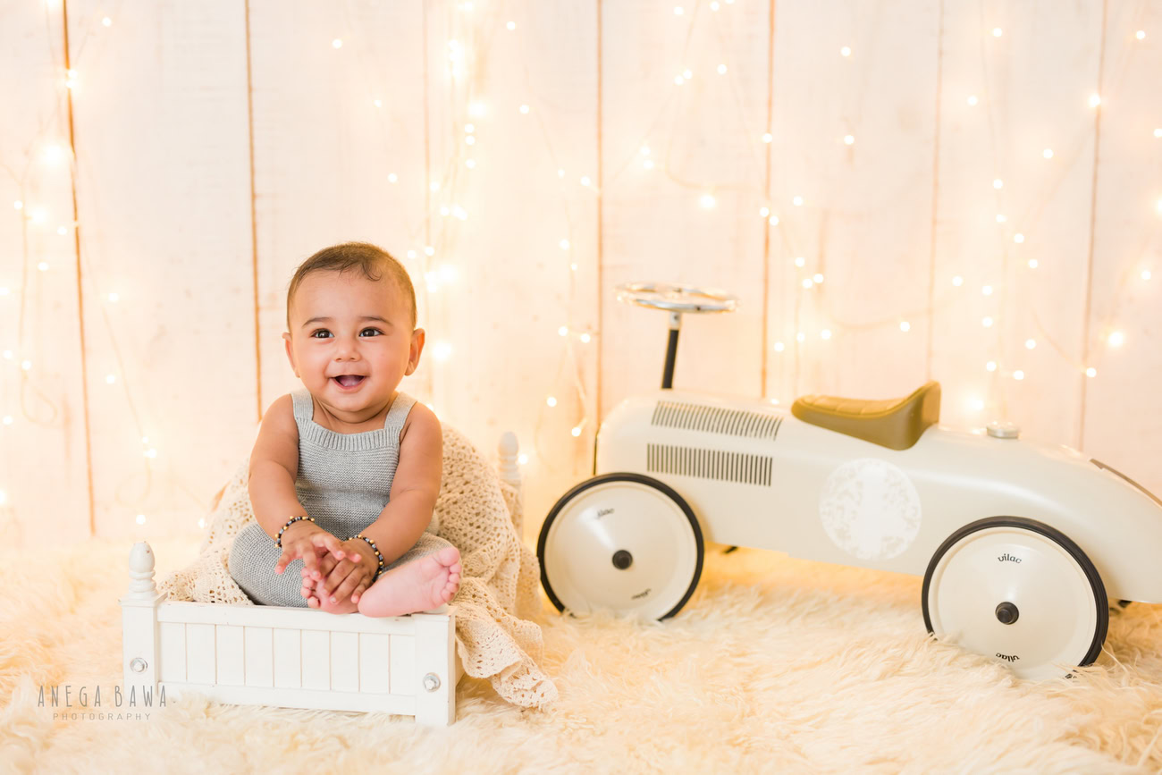 Baby boy photography, 5 or 4 or 3 or 6 months, beige backdrop, golden lights, toy car. Location: Delhi, Gurgaon, Noida. Photographer: Anega Bawa.