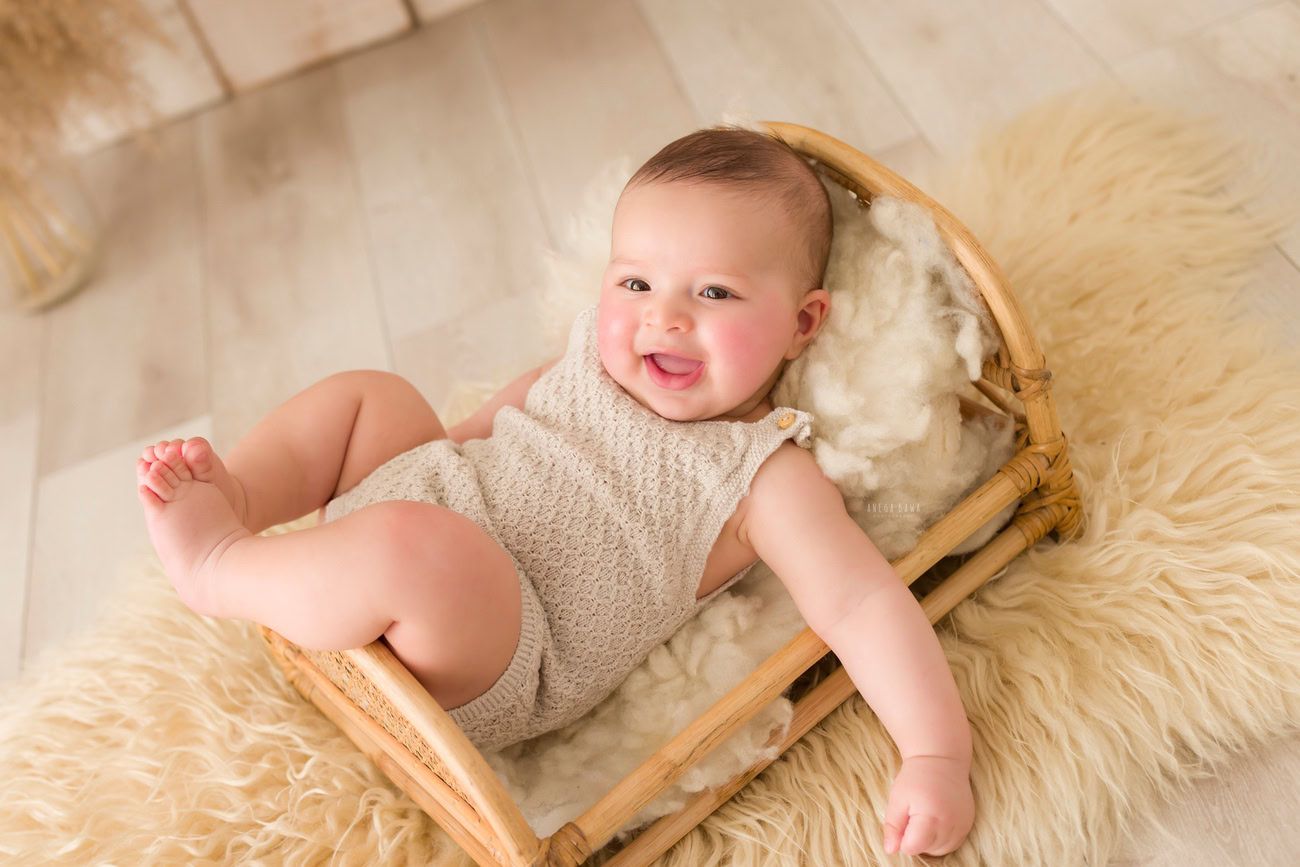 Baby boy photography, 5, 4, 3, or 6 months, beige rug, wooden cot, beige backdrop. Location: Delhi, Gurgaon, Noida. Photographer: Anega Bawa.