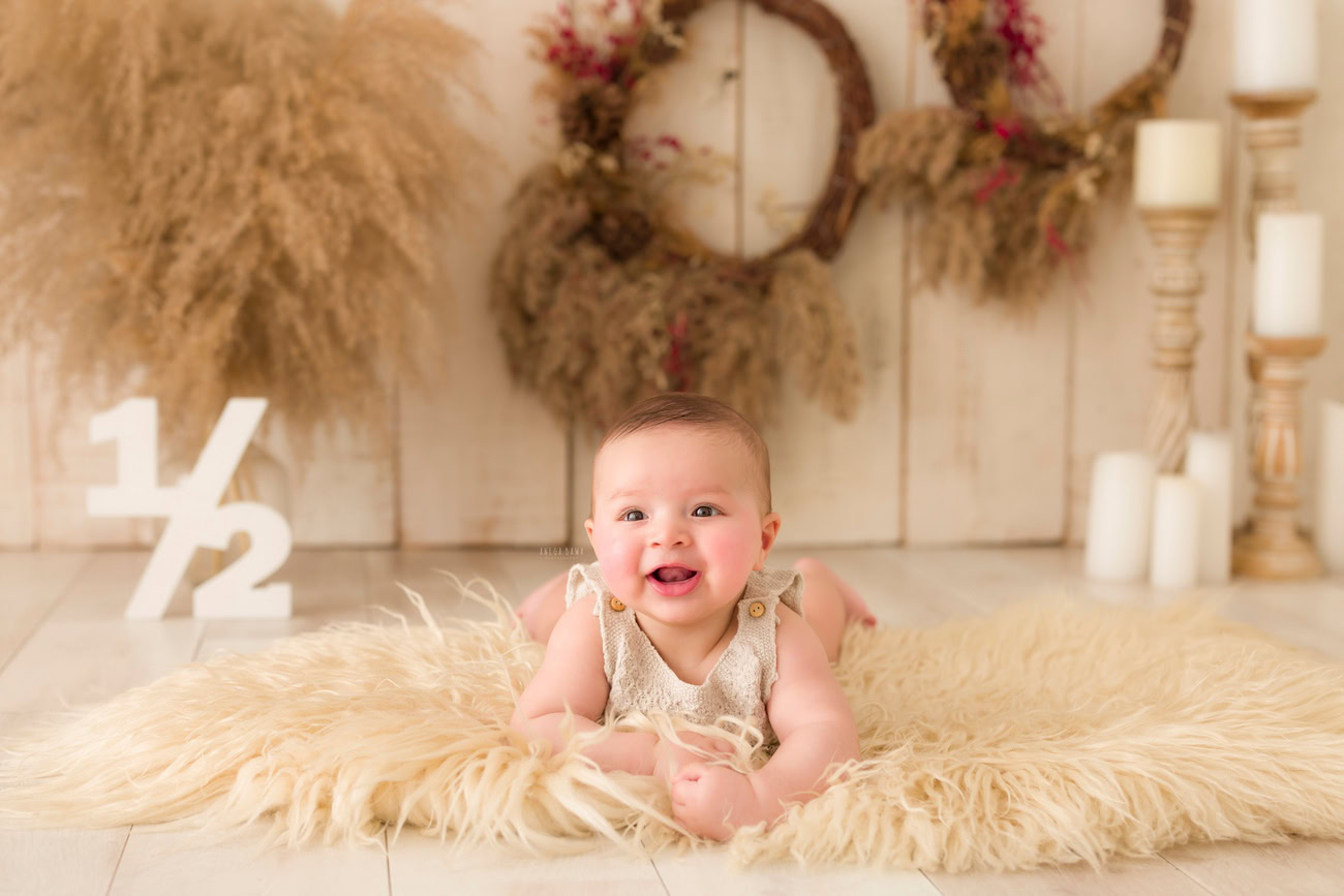 Baby boy photography, 5, 4, 3, or 6 months, beige rug, wooden frame, shrubs, candles, beige backdrop. Location: Delhi, Gurgaon, Noida. Photographer: Anega Bawa.
