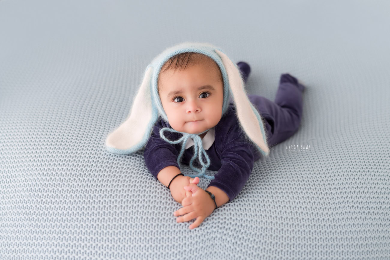 Baby boy photography, 5 or 4 or 3 or 6 months, blue baby boy suit, blue and white cap, blue backdrop. Location: Delhi, Gurgaon, Noida. Photographer: Anega Bawa.