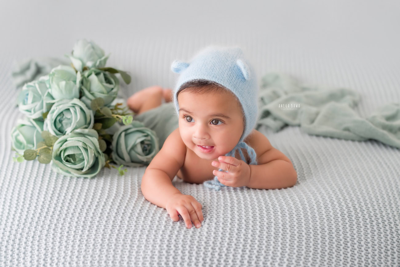 Baby boy photography, 5 or 4 or 3 or 6 months, blue cap, green flowers, grey backdrop. Location: Delhi, Gurgaon, Noida. Photographer: Anega Bawa.