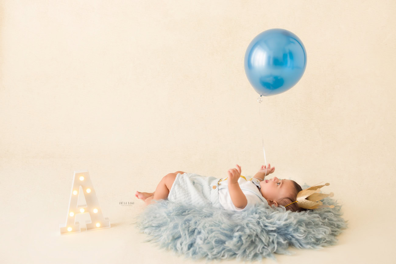 Baby boy photography, 5 or 4 or 3 or 6 months, blue rug, blue balloon, white backdrop, alphabet. Location: Delhi, Gurgaon, Noida. Photographer: Anega Bawa.