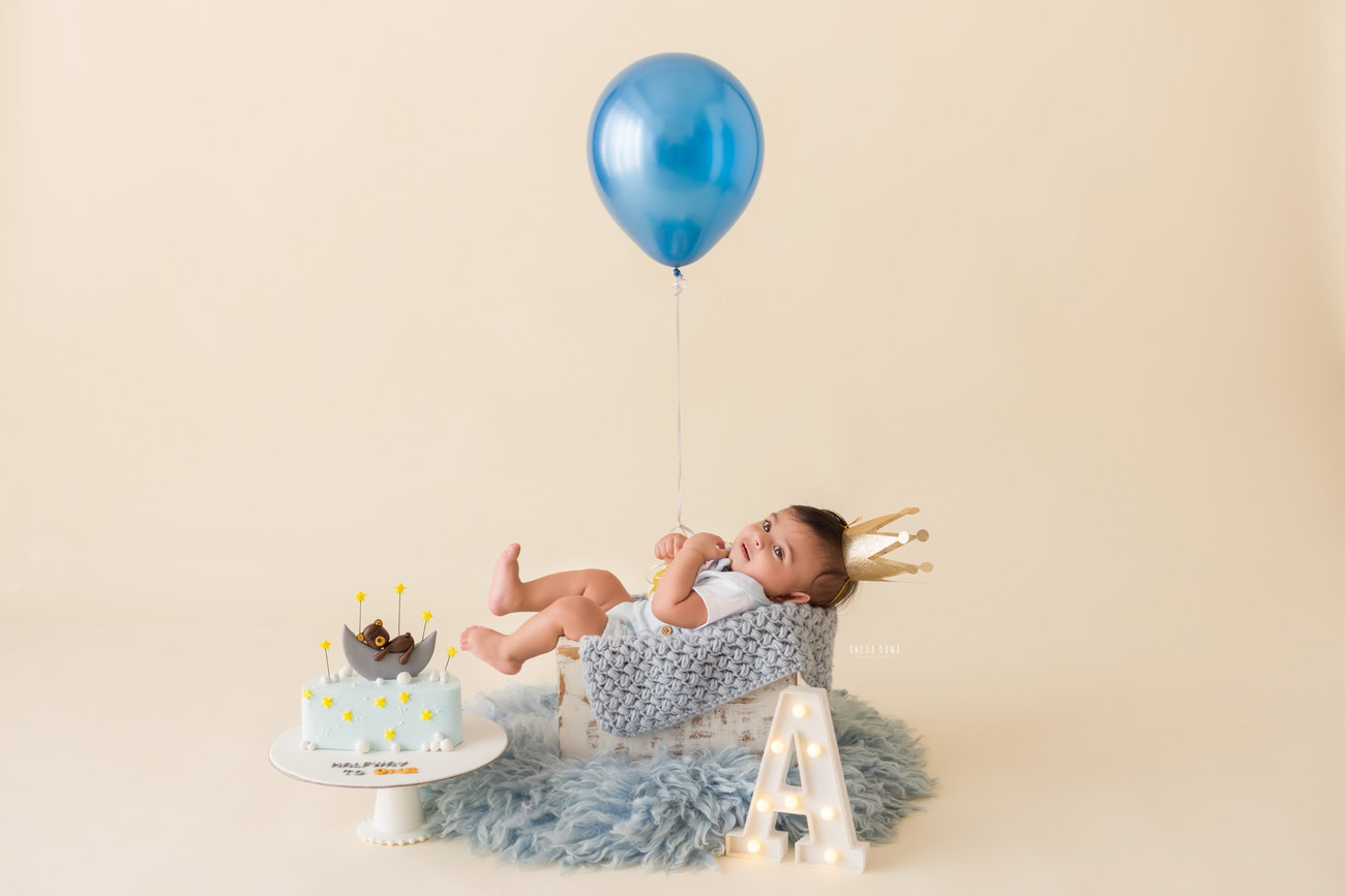 Baby boy photography, 5 or 4 or 3 or 6 months, blue rug, white backdrop, blue balloon, alphabet. Location: Delhi, Gurgaon, Noida. Photographer: Anega Bawa.