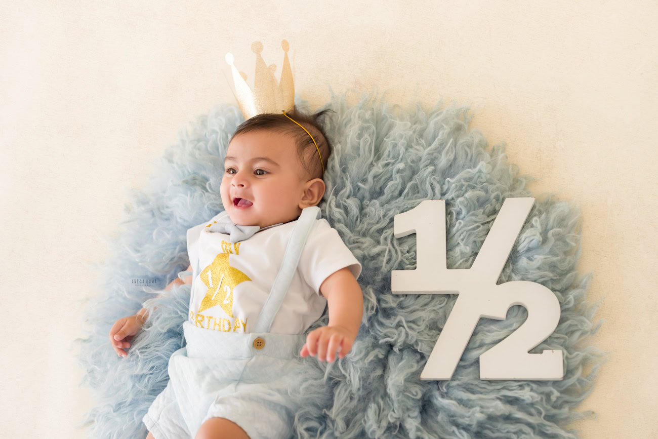 Baby boy photography, 5 or 4 or 3 or 6 months, blue rug, white backdrop, crown on head. Location: Delhi, Gurgaon, Noida. Photographer: Anega Bawa.