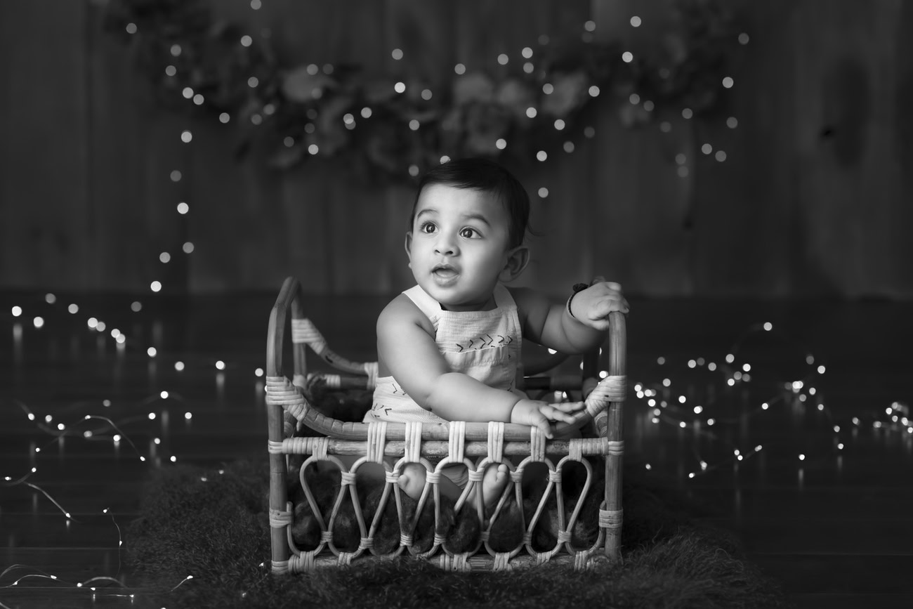 Book a photoshoot for your 5, 4, 3, or 6-month-old baby boy in Delhi, Gurgaon, or Noida with Anega Bawa. Let the warm glow of brown and golden lights against a black and white backdrop capture those precious moments.
