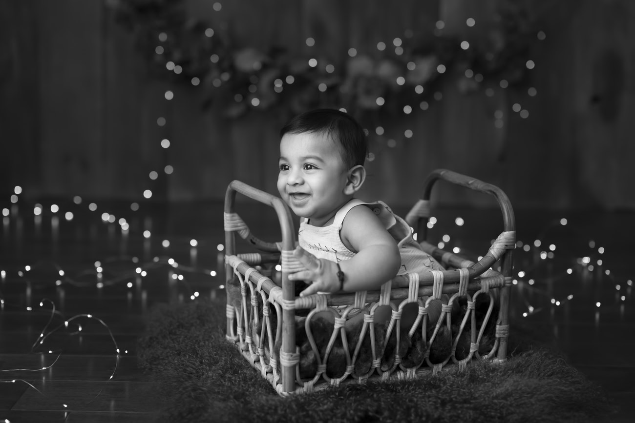 For a captivating baby boy photography session in Delhi, Gurgaon, or Noida, trust Anega Bawa. Capture the essence of your little one's innocence against a rustic brown wooden backdrop illuminated by golden lights, available for ages 3, 4, 5, or 6 months.