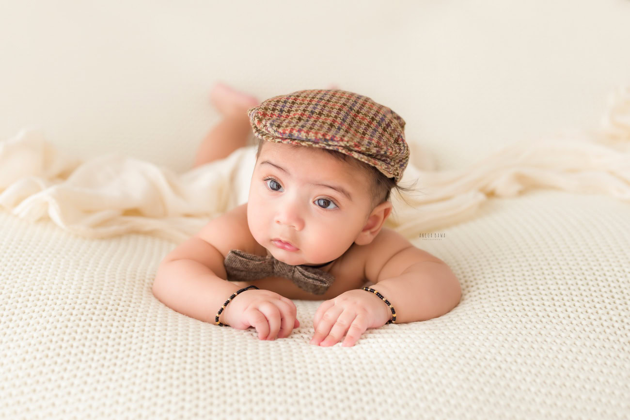 Baby boy photography, 5 or 4 or 3 or 6 months, cap, cute bow, white backdrop. Location: Delhi, Gurgaon, Noida. Photographer: Anega Bawa.