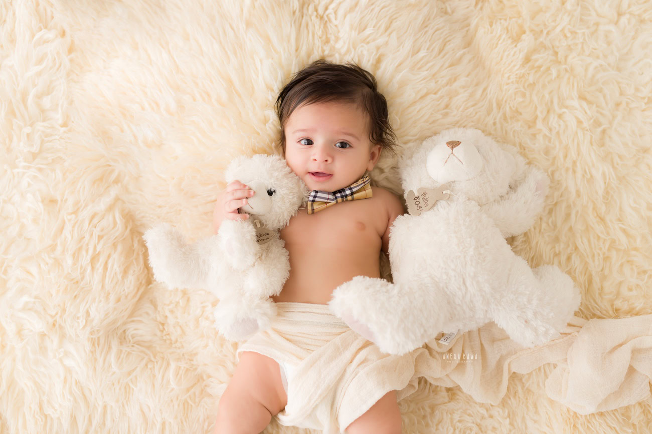 Baby boy photography, 5 or 4 or 3 or 6 months, cute bow, beige rug, soft toy, beige backdrop. Location: Delhi, Gurgaon, Noida. Photographer: Anega Bawa.