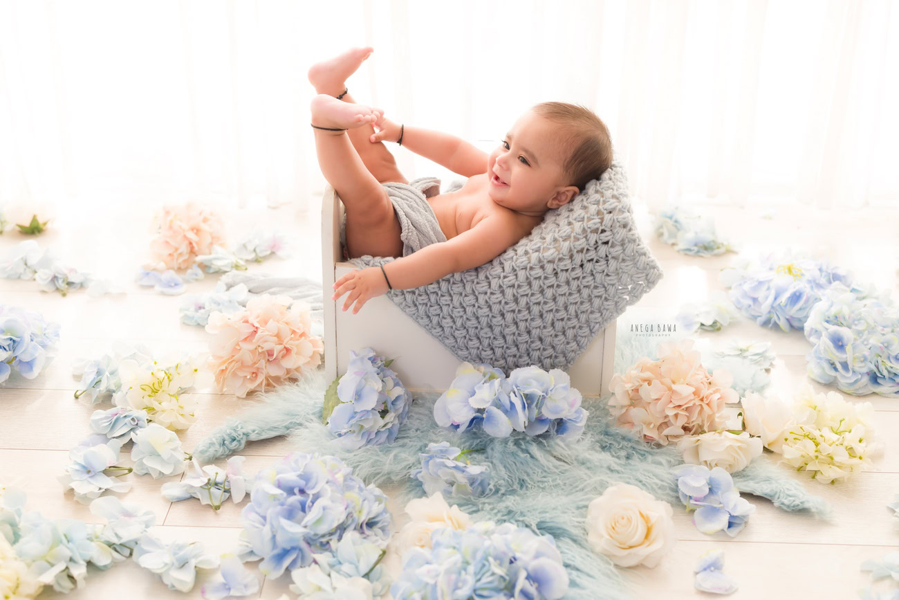 Baby boy photography, 5 or 4 or 3 or 6 months, grey wrap, multicolor flowers, white backdrop. Location: Delhi, Gurgaon, Noida. Photographer: Anega Bawa.