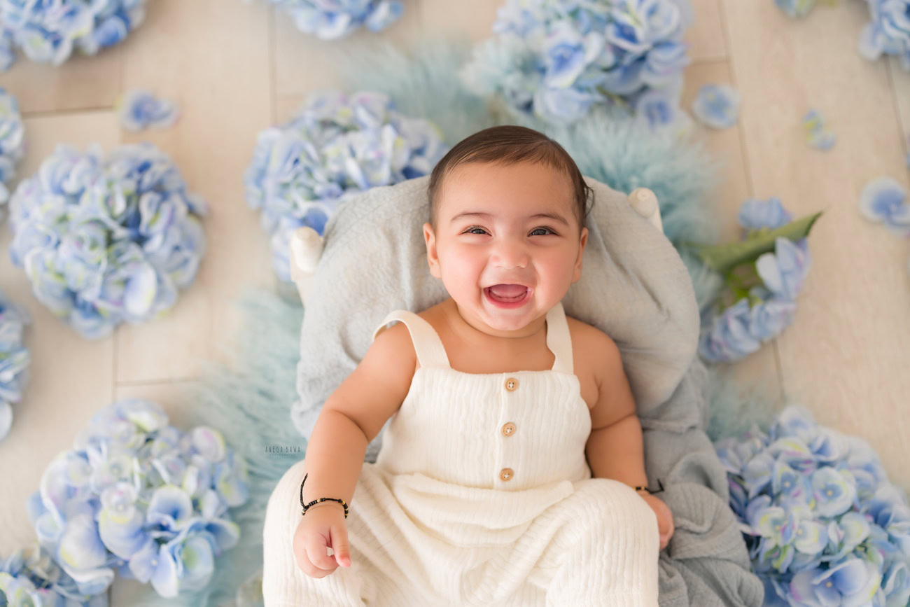 Baby boy photography, 5 or 4 or 3 or 6 months, white baby boy suit, blue flowers. Location: Delhi, Gurgaon, Noida. Photographer: Anega Bawa.