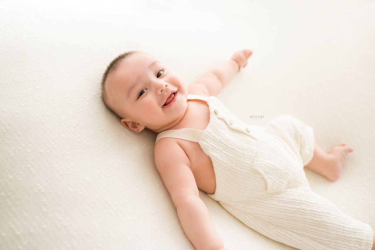 Baby boy photography, 5, 4, 3, or 6 months, white baby boysuit, white backdrop. Location: Delhi, Gurgaon, Noida. Photographer: Anega Bawa.