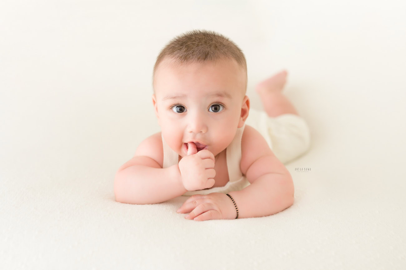 Baby boy photography, 5, 4, 3, or 6 months, white baby boysuit, white backdrop. Location: Delhi, Gurgaon, Noida. Photographer: Anega Bawa.