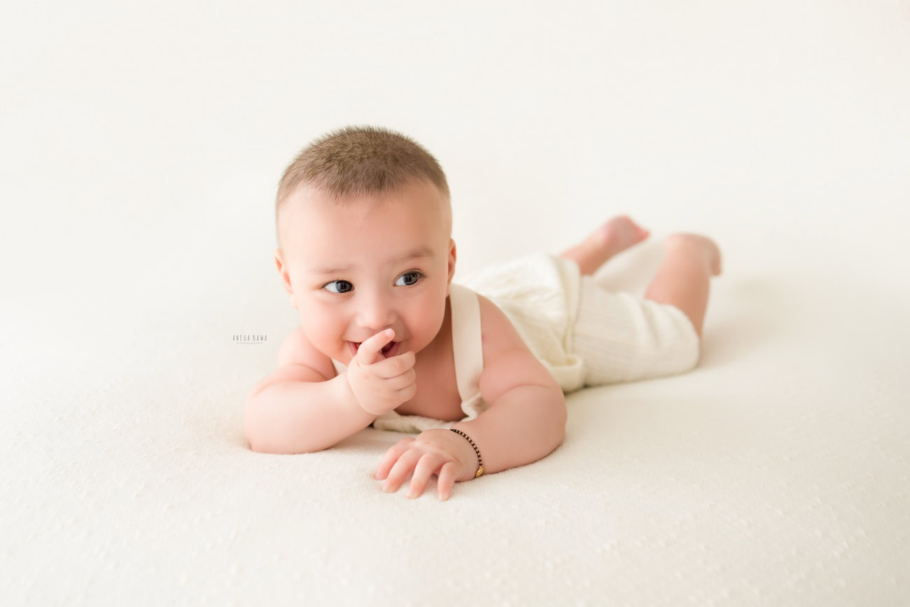Baby boy photography, 5, 4, 3, or 6 months, white baby boysuit, white backdrop. Location: Delhi, Gurgaon, Noida. Photographer: Anega Bawa.