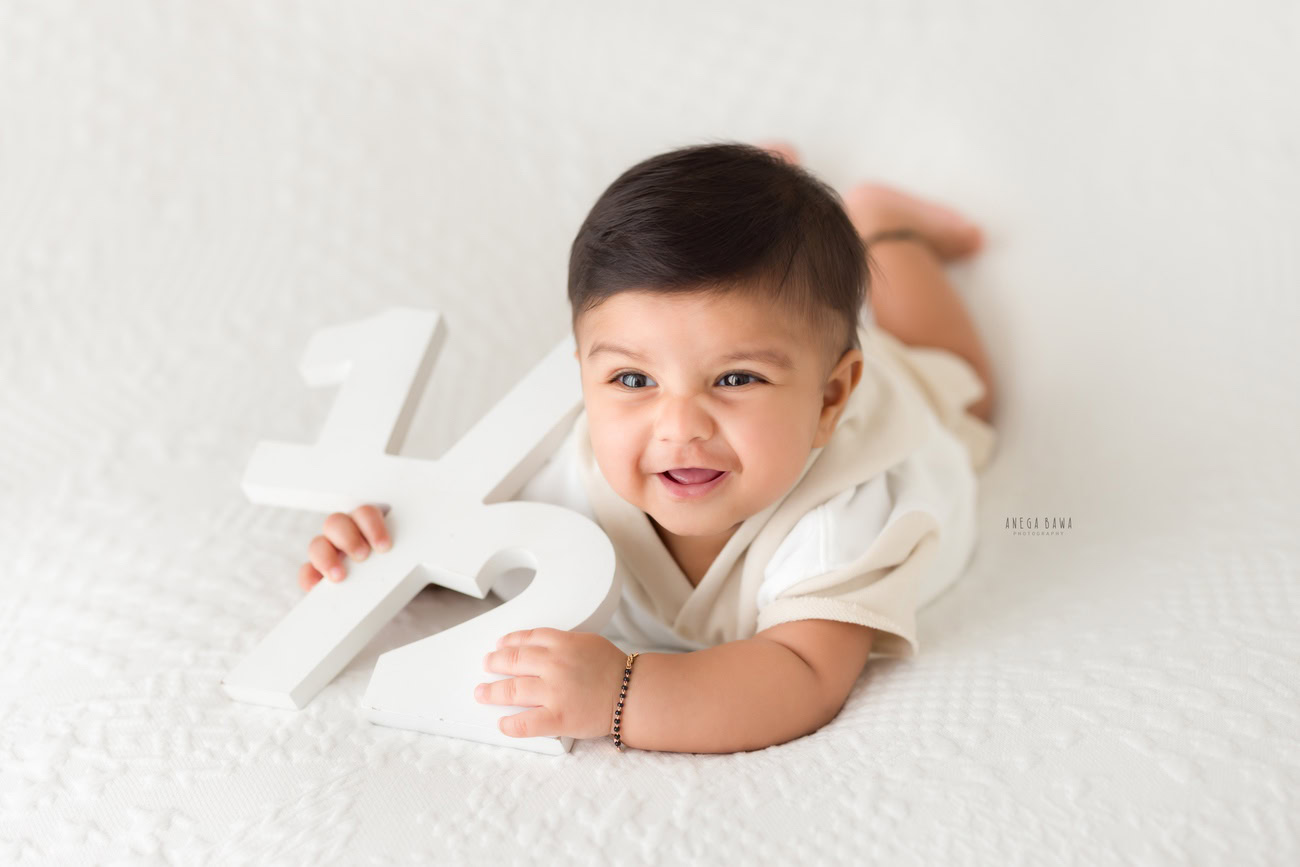 Baby boy photography, 5 or 4 or 3 or 6 months, white backdrop, cute laughing pose. Location: Delhi, Gurgaon, Noida. Photographer: Anega Bawa.