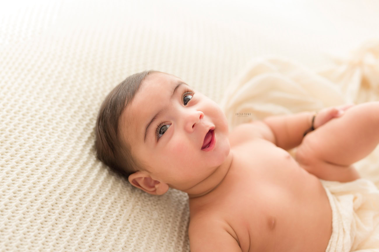 Baby boy photography, 5 or 4 or 3 or 6 months, white backdrop, cute smiling pose. Location: Delhi, Gurgaon, Noida. Photographer: Anega Bawa.