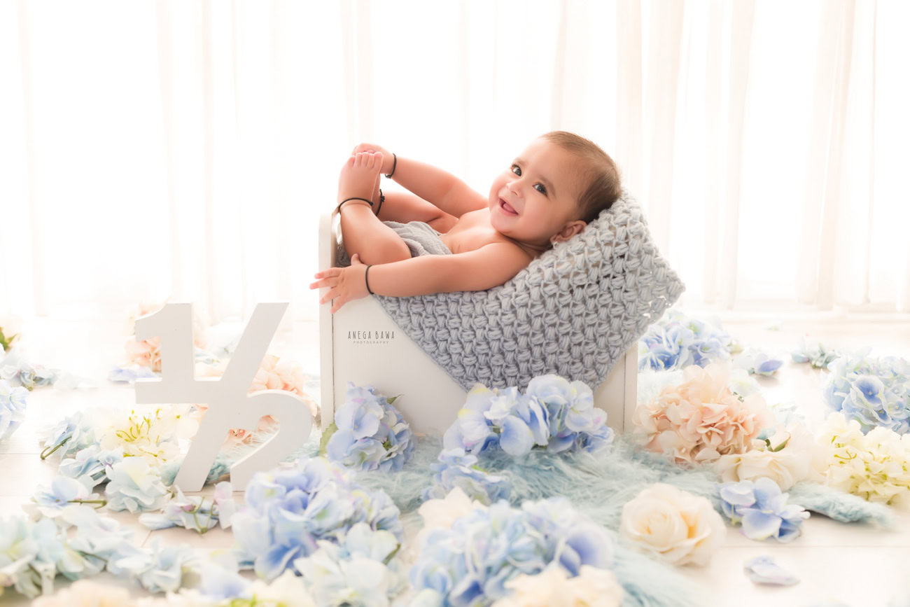 Baby boy photography, 5 or 4 or 3 or 6 months, white wooden basket, blue and white flowers. Location: Delhi, Gurgaon, Noida. Photographer: Anega Bawa.