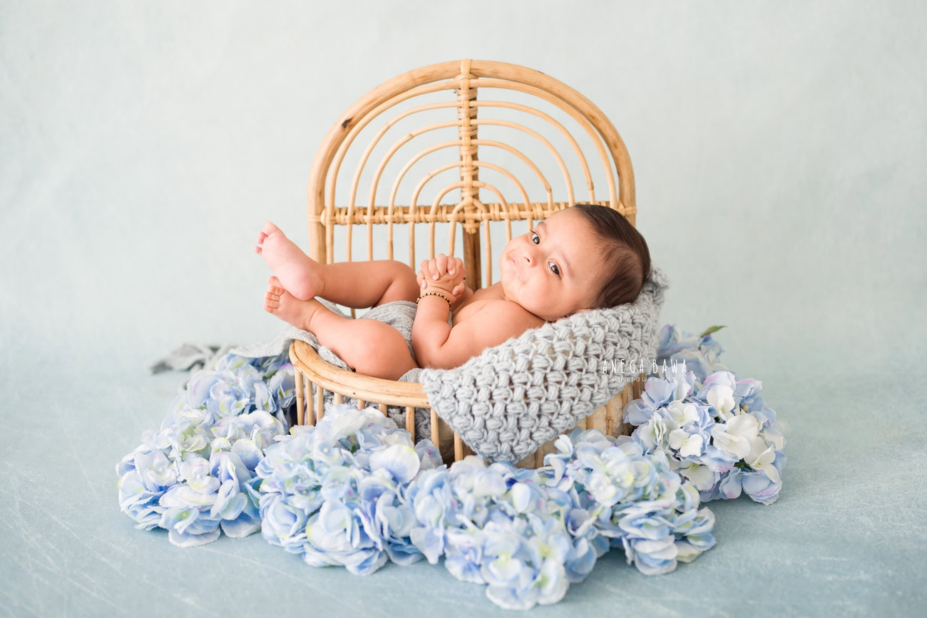 Baby boy photography, 5, 4, 3, or 6 months, wooden cot, blue backdrop, blue floral curve. Location: Delhi, Gurgaon, Noida. Photographer: Anega Bawa.
