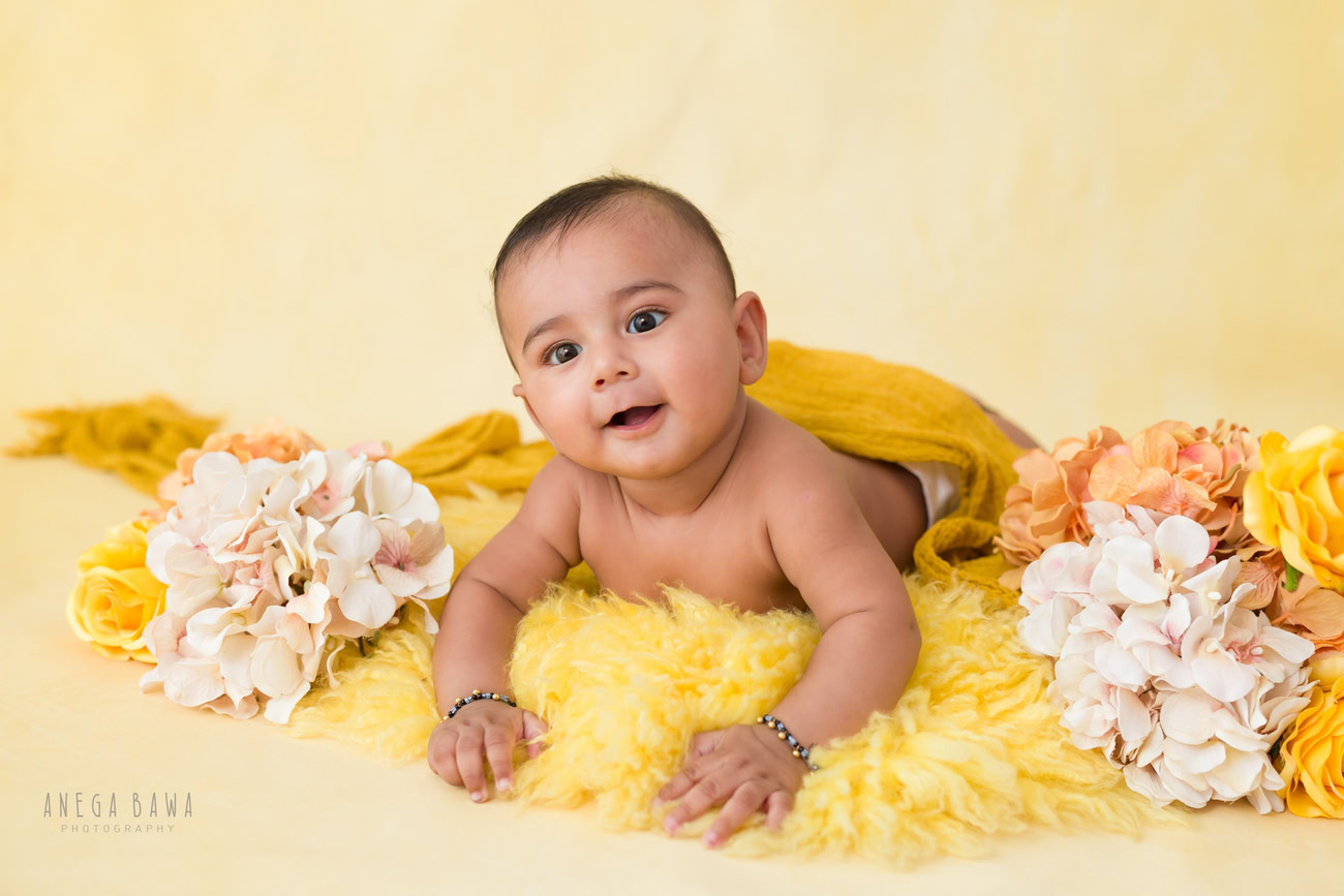 Baby boy photography, 5 or 4 or 3 or 6 months, yellow rug, yellow backdrop, yellow wrap, cute pose. Location: Delhi, Gurgaon, Noida. Photographer: Anega Bawa.