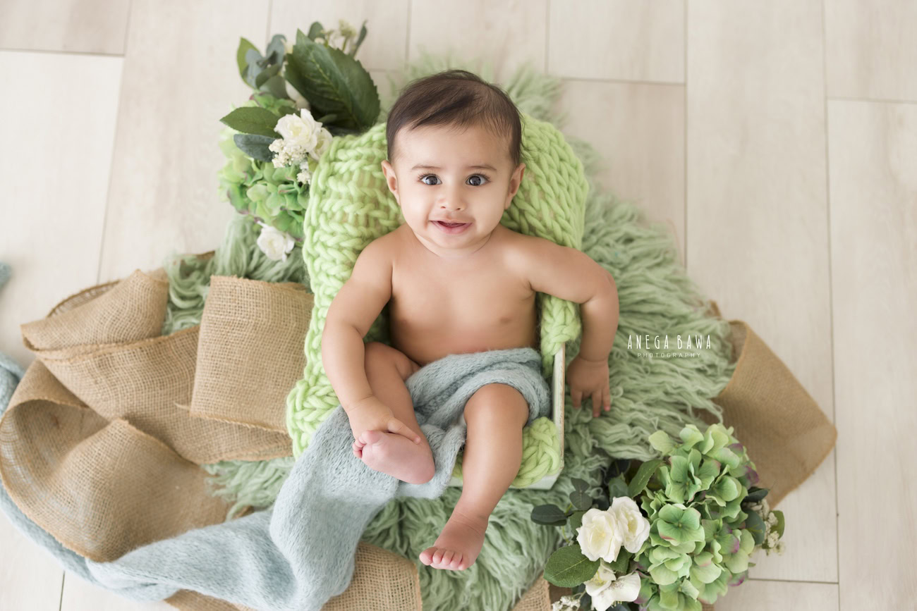 Baby boy photoshoot, 6, 5, 4, 3 months, beige backdrop, blue wrap, green rug, top view. Location: Delhi, Gurgaon, Noida. Photographer: Anega Bawa.