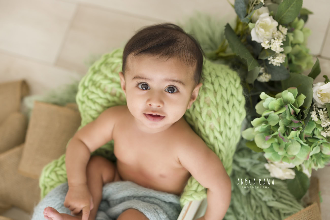 Baby boy photoshoot, 6, 5, 4, 3 months, beige backdrop, blue wrap, white flowers. Location: Delhi, Gurgaon, Noida. Photographer: Anega Bawa.