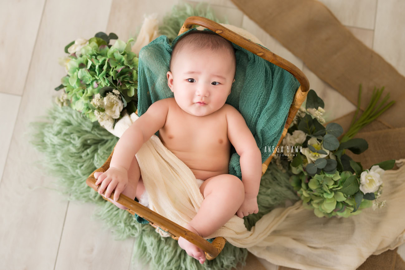 Baby boy photoshoot, 6, 5, 4, 3 months, beige sheet, green rug, leafy curve, beige backdrop. Location: Delhi, Gurgaon, Noida. Photographer: Anega Bawa.