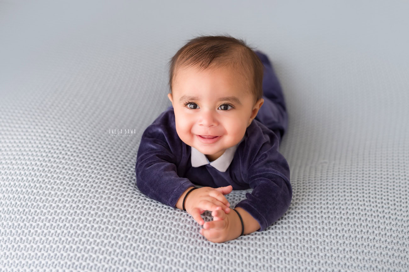 Baby boy photoshoot, 6 or 5 or 4 or 3 months, grey backdrop, cute smiling pose. Location: Delhi, Gurgaon, Noida. Photographer: Anega Bawa.
