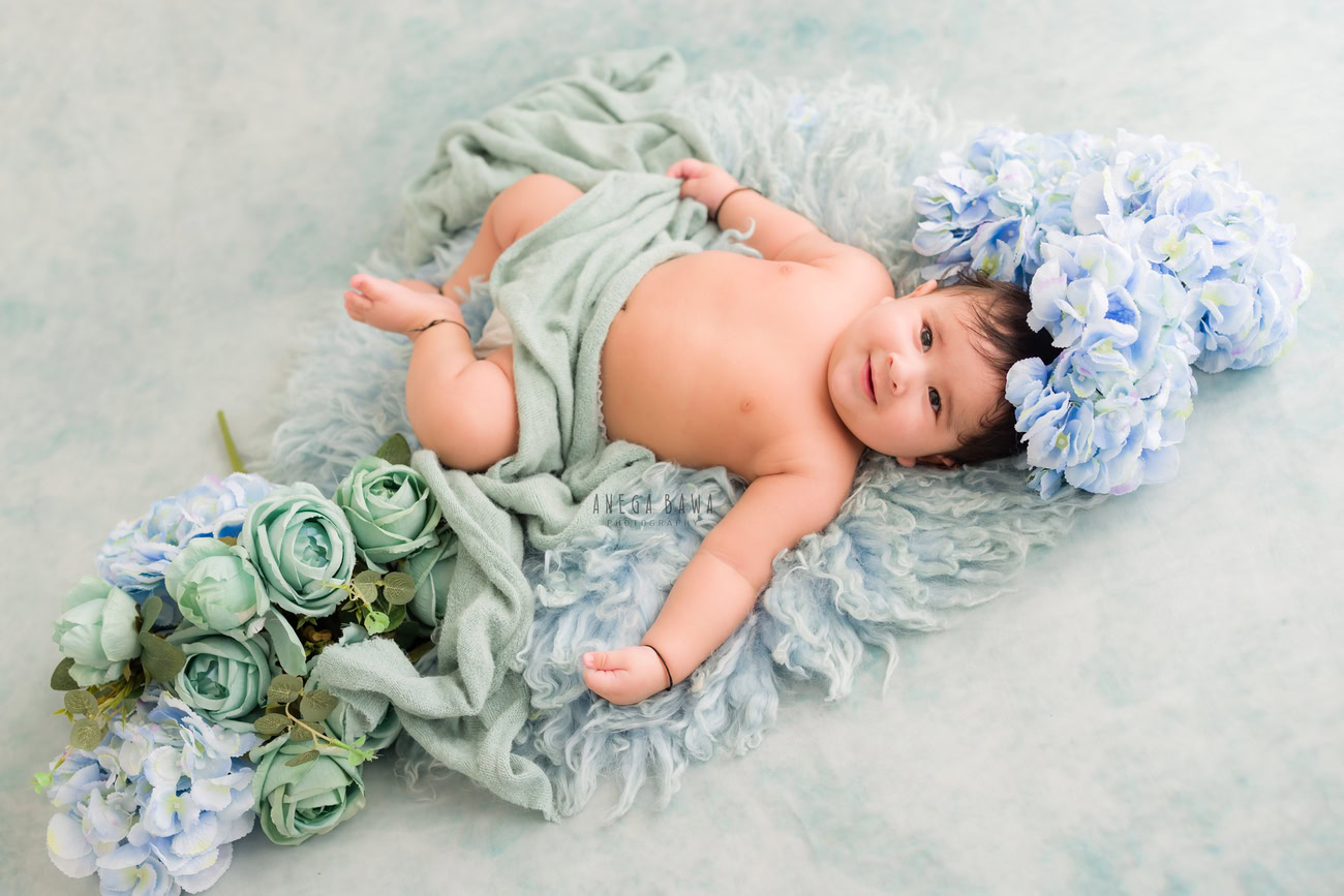 Baby boy photoshoot, 6, 5, 4, 3 months, grey backdrop, grey sheet, blue flowers. Location: Delhi, Gurgaon, Noida. Photographer: Anega Bawa.