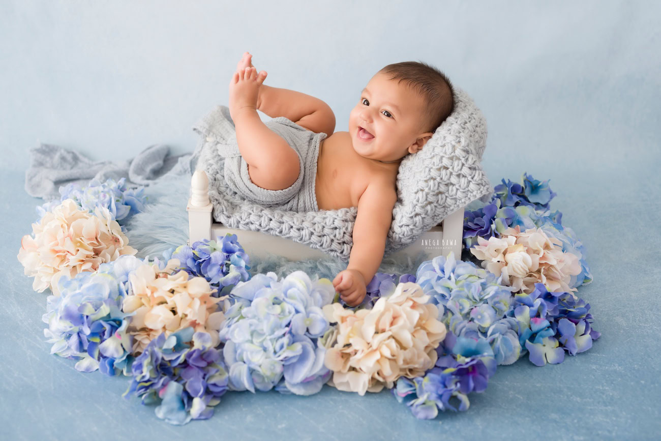 Baby boy photoshoot, 6 or 5 or 4 or 3 months, grey backdrop, grey wrap, flowers. Location: Delhi, Gurgaon, Noida. Photographer: Anega Bawa.