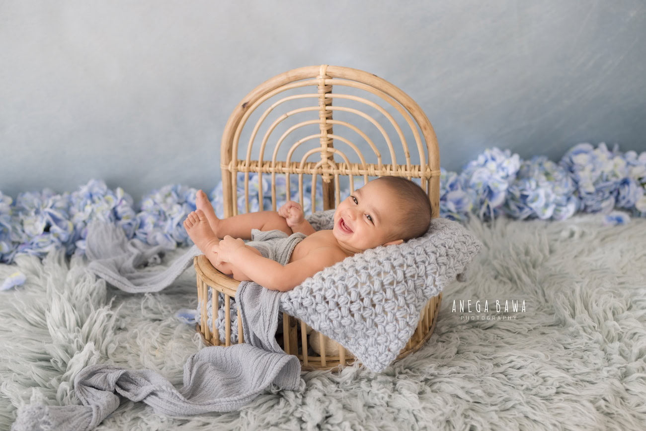 Baby boy photoshoot, 6 or 5 or 4 or 3 months, grey rug, blue backdrop, blue flowers, wooden cot, grey wrap, Delhi Gurgaon Noida, Anega Bawa.