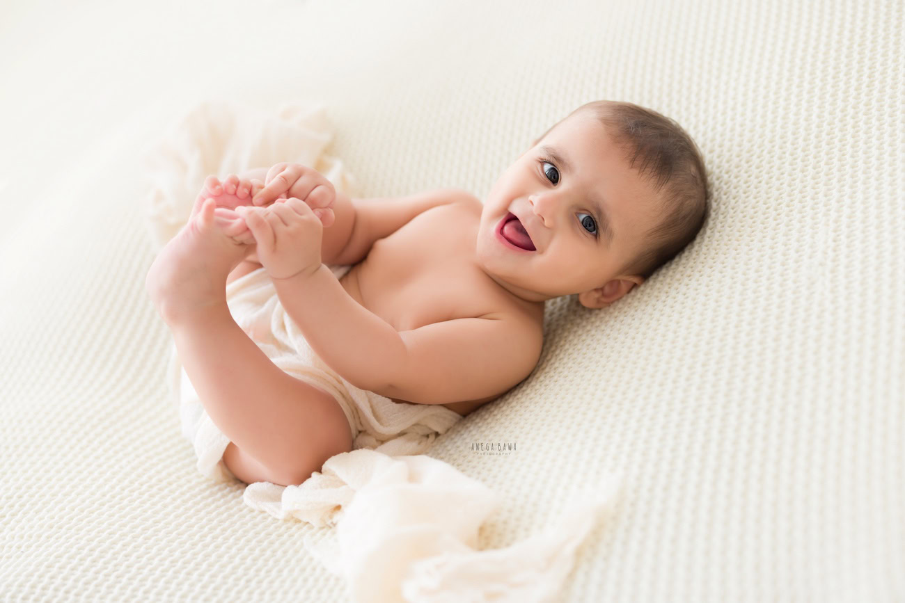 Baby boy photoshoot, 6 or 5 or 4 or 3 months, white backdrop, cute laughing pose, white wrap. Location: Delhi, Gurgaon, Noida. Photographer: Anega Bawa.