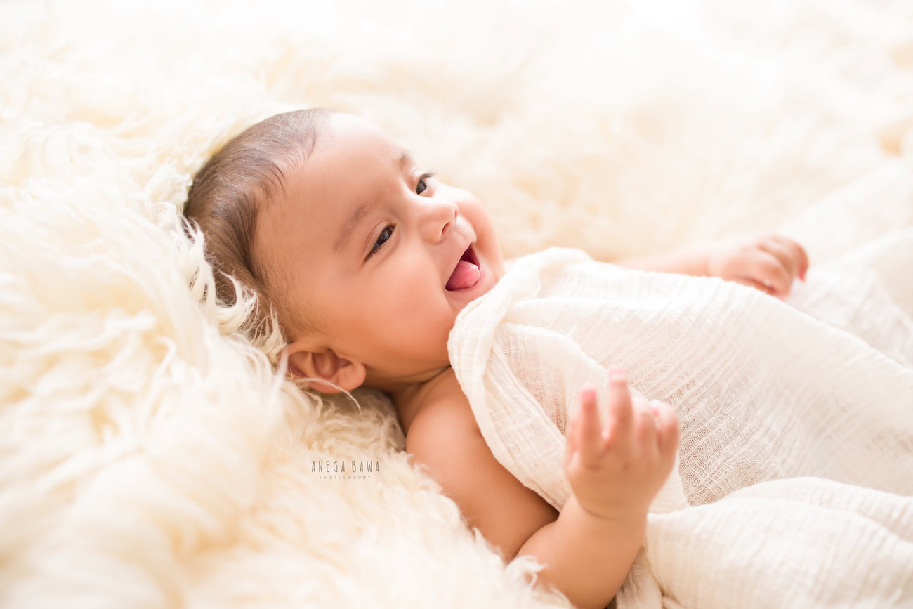 Capture the innocence of your baby boy aged 3, 4, 5, or 6 months in a serene white setting, with a white rug and wrap, in a sweet lying down pose. Contact Anega Bawa for your photoshoot in Delhi, Gurgaon, or Noida.