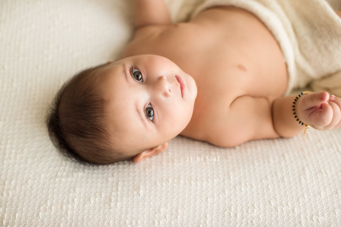Create cherished memories of your baby boy's early months with a serene and pure photoshoot. Adorned in a white wrap and lying on a soft white sheet, set against a pristine white backdrop, capture these precious moments with Anega Bawa in Delhi, Gurgaon, or Noida.